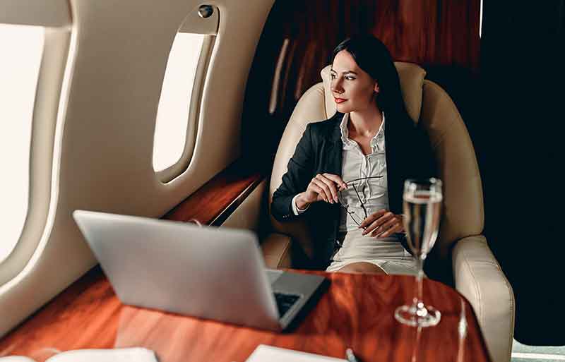 First time private jet flyer sits at a table with a glass of champagne on top