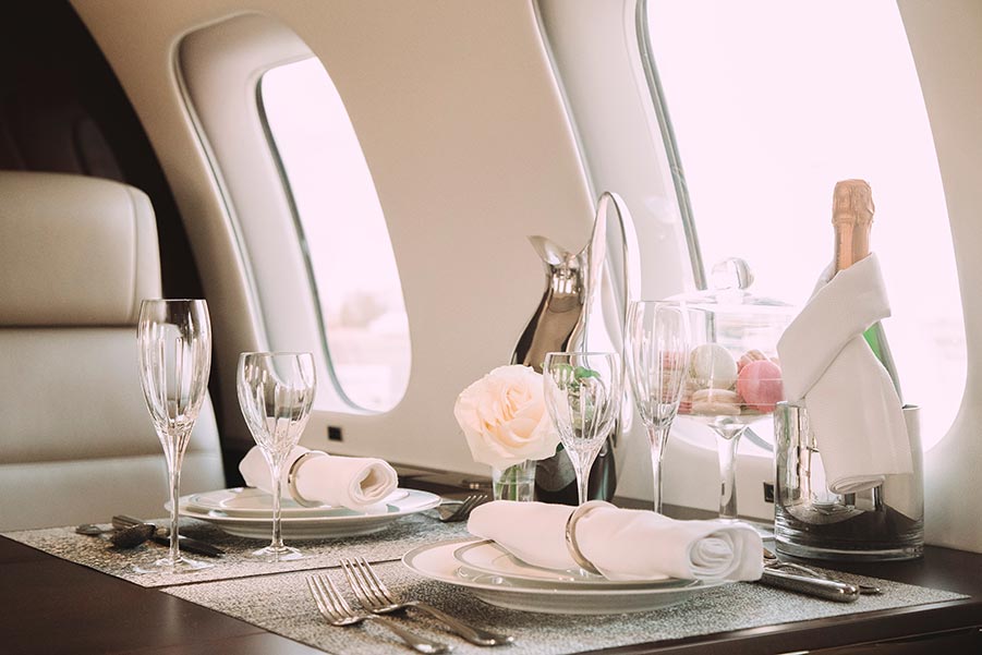 In-Flight Catering Place Settings on Private Jet showing Champagne, and Macarons Ready for Guests - Paramount