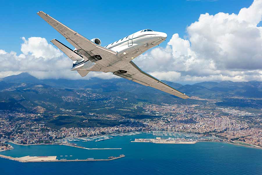 Private Jet Charter Flying Over Mountains & Water - Paramount Business Jets