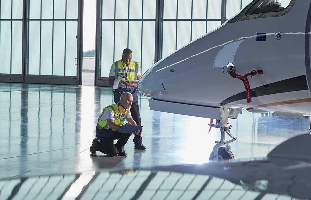 Safety crew checks private jet in hangar